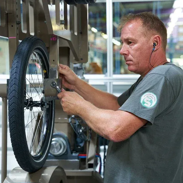 Opérateur Mach1 montant une roue équipée d'un pneu sur un banc de roulage