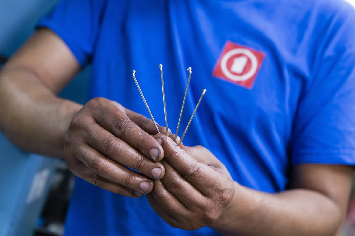 Mains d'un opérateur Mach1 tenant quatre rayons en acier à tête coudée